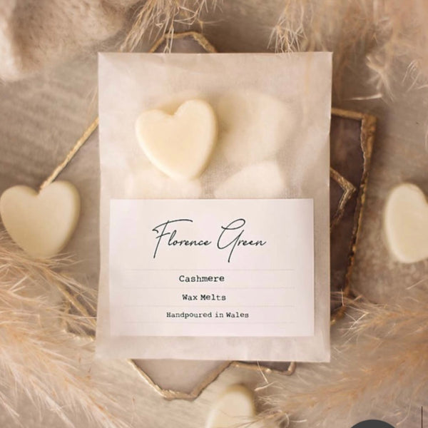 Packet of Cashmere scented vegetable wax melts from Florence green on a beige background