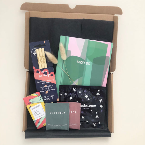 Little Box of stationery that is letterbox friendly includes A5 lined notebook, pack of 3 recycled pencils, self heating eye mask from Spacemasks and 2 sachets of organic tea on white background