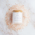 Glass jar of lavender and rose vegan 'Beauty Sleep' bath salts from British Brand Salt and Steam on a white background with salts for added effect