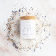 Glass jar of lavender and rose vegan bath salts from British brand Salt and steam on a white background with added flower petals for decoration