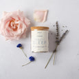 Glass jar of lavender and rose vegan 'Beauty Sleep' bath salts from British Brand Salt and Steam on a white background - with added florals