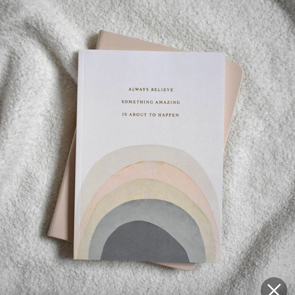 A5 FSC pastel rainbow notebook from Tres paper co with the words 'always believe something amazing is abut to happen' gold foil printed on the front.