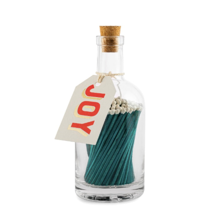 Apothecary Glass bottle containing long green matches with a coloured tag with the word Joy on a white background