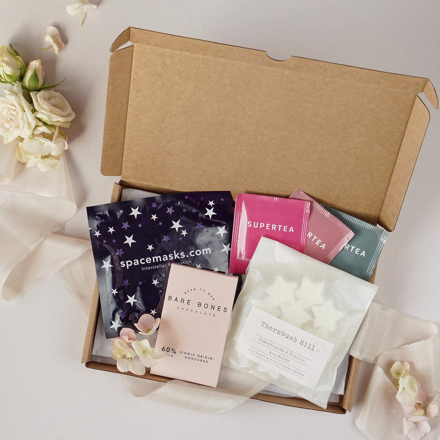 Letterbox friendly little box of calm contains self heating spacemask 10 soy wax melts trio of organic teas and small bar of artisan milk chocolate bar 