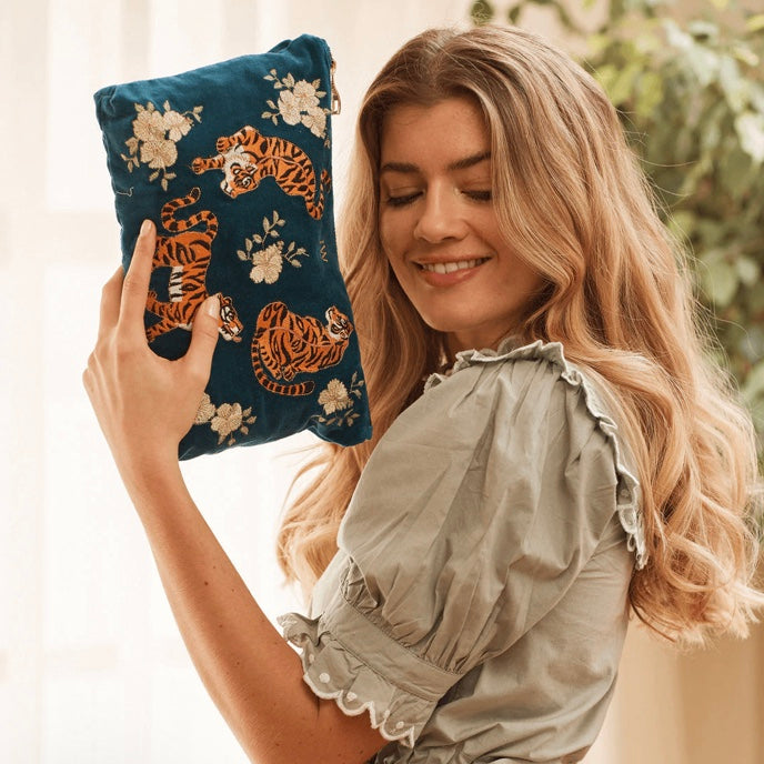 Lady holding velvet pouch featuring embroidered tigers and flowers from Elizabeth Scarlett