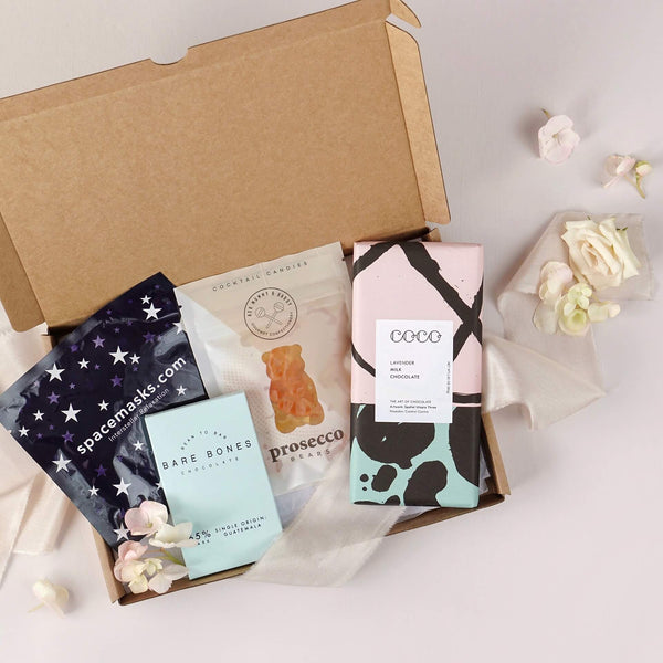 Sweet treats letterbox friendly gift box contains large bar of Salted caramel chocolate, prosecco gummy bears, small dark chocolate bar from coco Chocolatier and self heating eye mask from Spacemasks