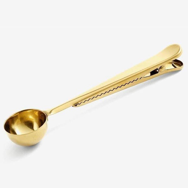 Coffee measuring scoop 10g in a gold colour with clip on a white background