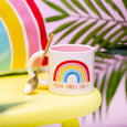 Image of rainbow mug with slogan good vibes only on a decorative background