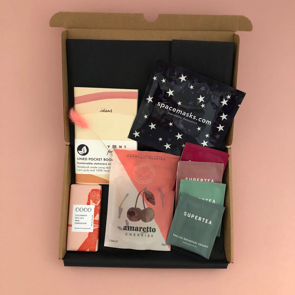 Recharge letterbox friendly gift box includes A6 ideas pink notebook, spacemask, 4 sachets of organic tea, mini artisan chocolate bar and a packed of Prosecco gummy bears