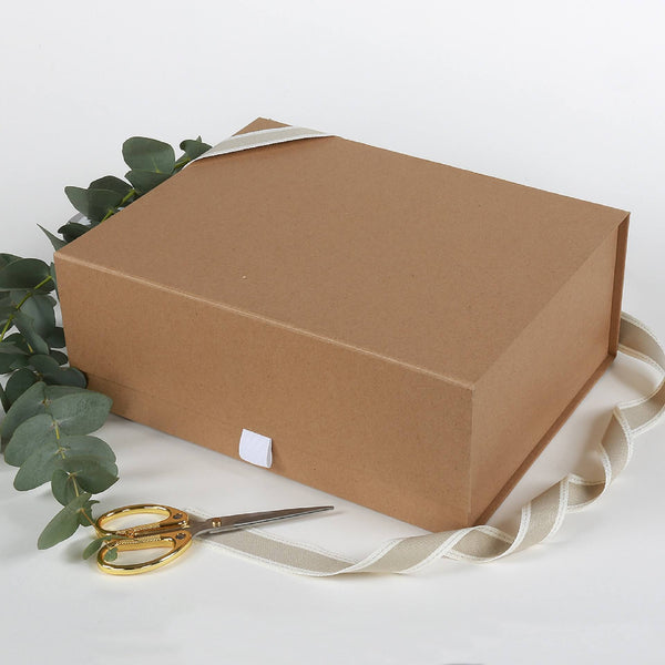 Large kraft coloured gift box with ribbon and a card included on a white background