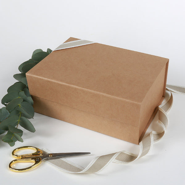 Small kraft coloured gift box with ribbon and card included on a white background
